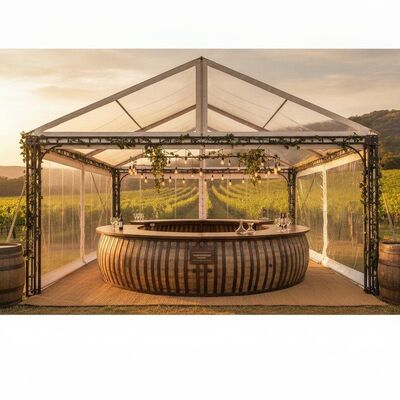 Tenda para festa no vinhedo com balcão de degustação integrado, madeira rústica, estética e clara, painéis de PVC com vista para o vinhedo